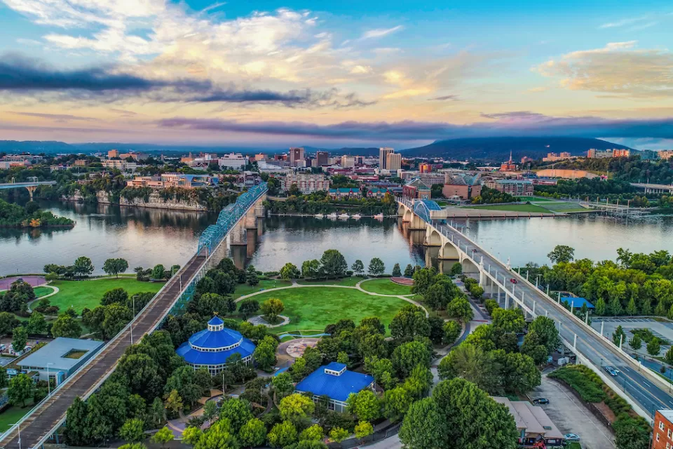 Aerial view of Chattanooga, Tennessee with two bridges over river in background.